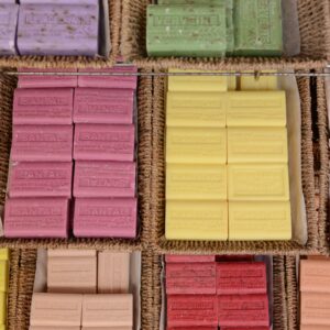A vibrant display of handmade soaps in various colors and scents at a market.